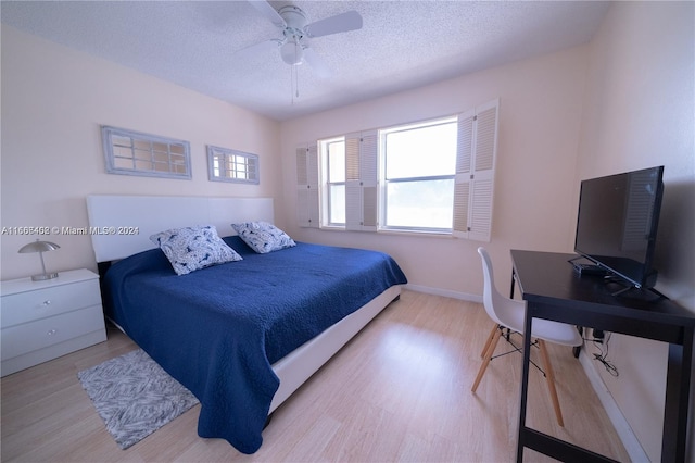 bedroom featuring ceiling fan, a textured ceiling, and light wood-type flooring