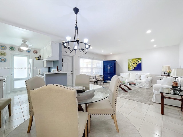 tiled dining area featuring ceiling fan with notable chandelier