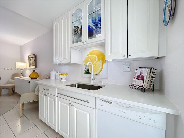 kitchen with white dishwasher, white cabinets, light tile patterned floors, and sink