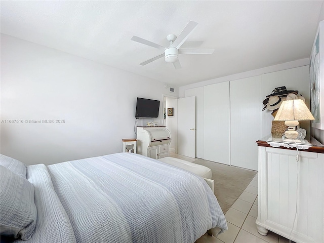 bedroom with light tile patterned floors, a closet, and ceiling fan