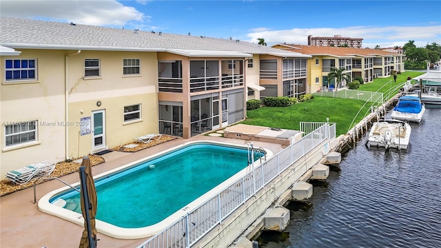 view of swimming pool with a yard and a water view