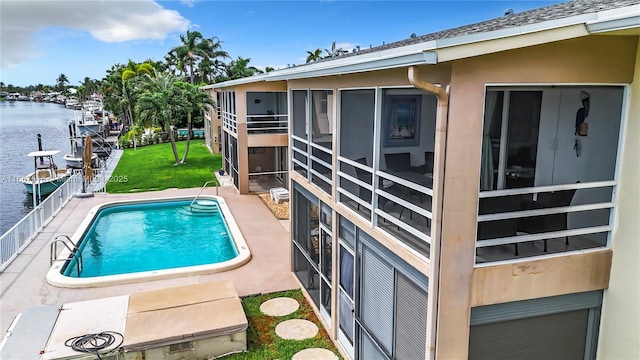 view of swimming pool with a water view and a yard