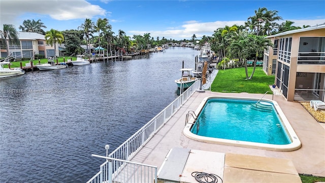 view of swimming pool with a water view and a yard