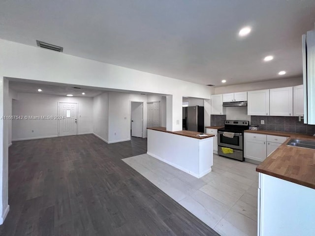 kitchen featuring wood counters, sink, white cabinets, light hardwood / wood-style flooring, and stainless steel appliances