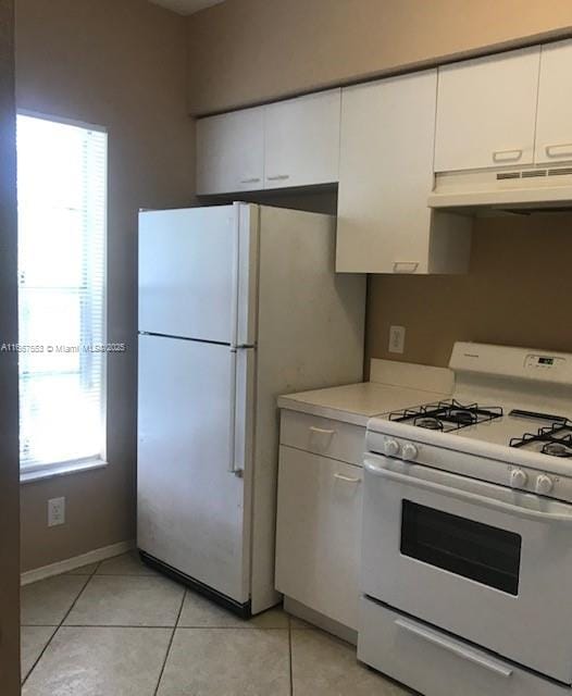 kitchen with a healthy amount of sunlight, white appliances, and white cabinets