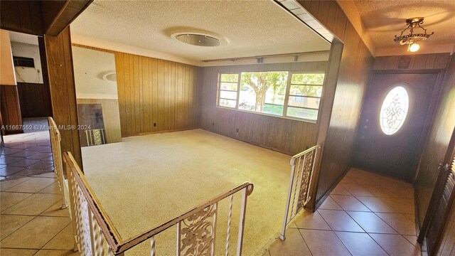 3230 N 23rd Ave, Hollywood, FL 33020 - foyer entrance featuring wood walls, light tile patterned floors, a textured ceiling, and light colored carpet