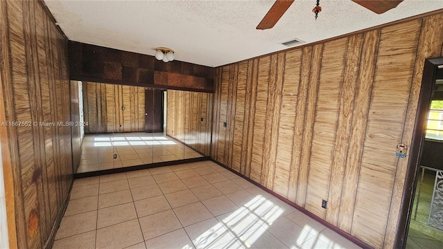 3230 N 23rd Ave, Hollywood, FL 33020 - spare room featuring wood walls, a textured ceiling, a ceiling fan, and light tile patterned flooring