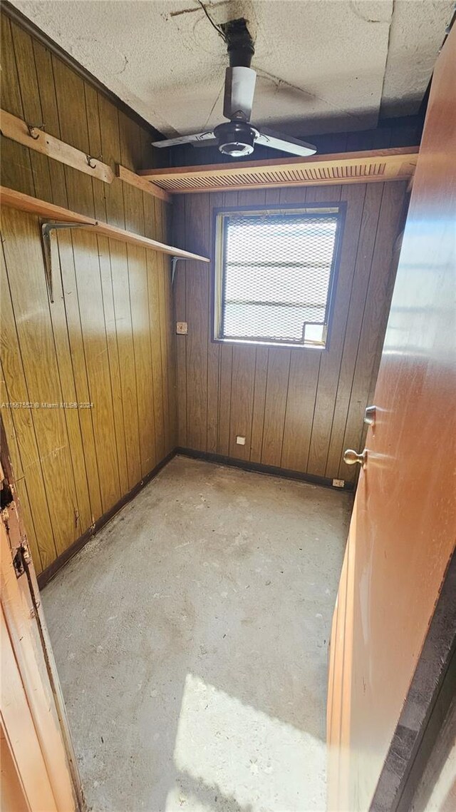 3230 N 23rd Ave, Hollywood, FL 33020 - spare room featuring wooden walls, ceiling fan, a textured ceiling, and unfinished concrete floors
