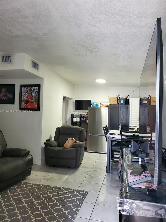 tiled living room featuring a textured ceiling