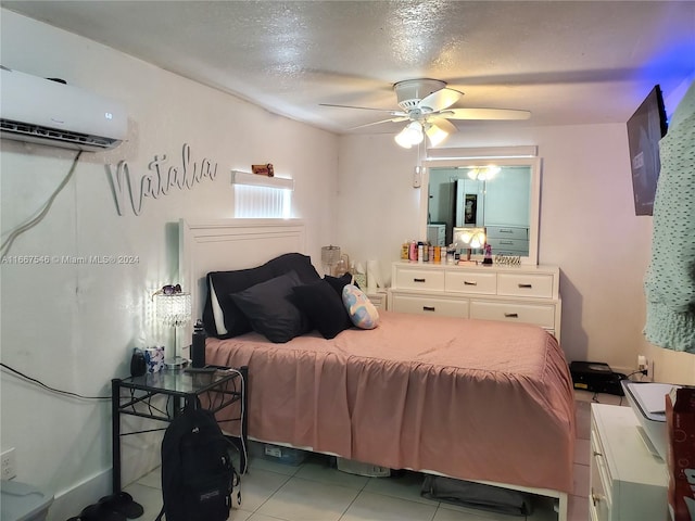 bedroom with a textured ceiling, light tile patterned floors, ceiling fan, and a wall mounted air conditioner