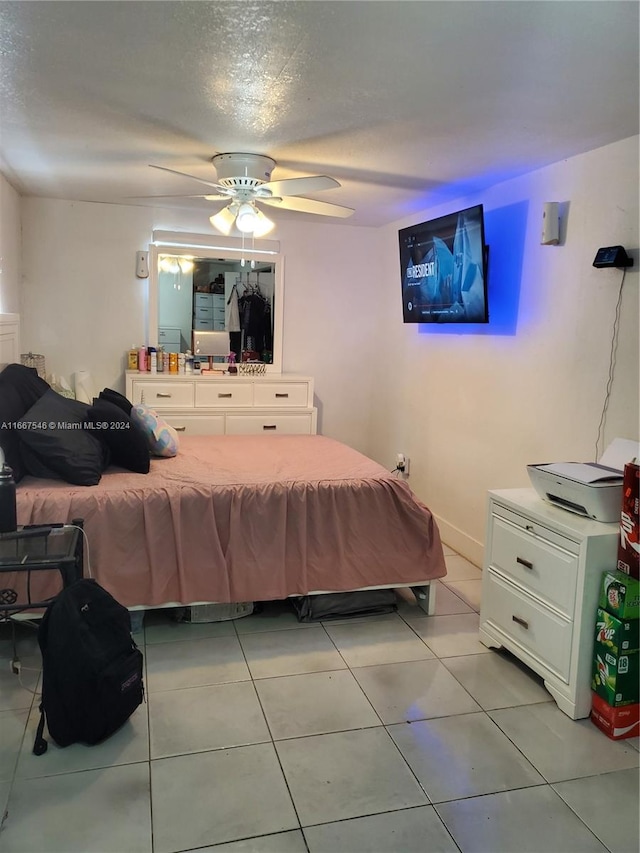 tiled bedroom with ceiling fan and a textured ceiling