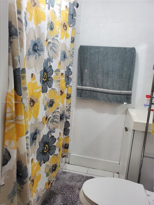 bathroom featuring a shower with curtain, vanity, tile patterned flooring, and toilet