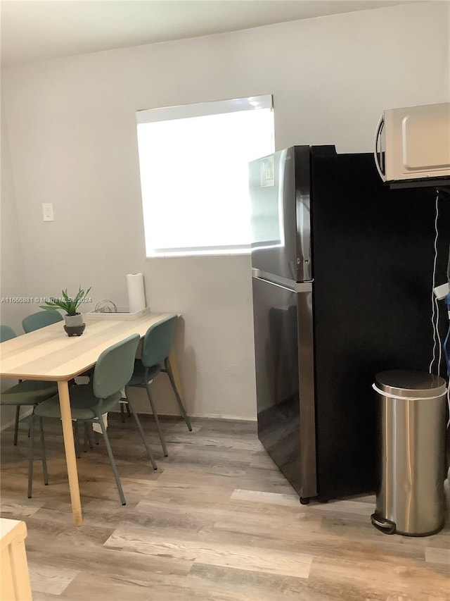 kitchen with stainless steel refrigerator and light hardwood / wood-style flooring