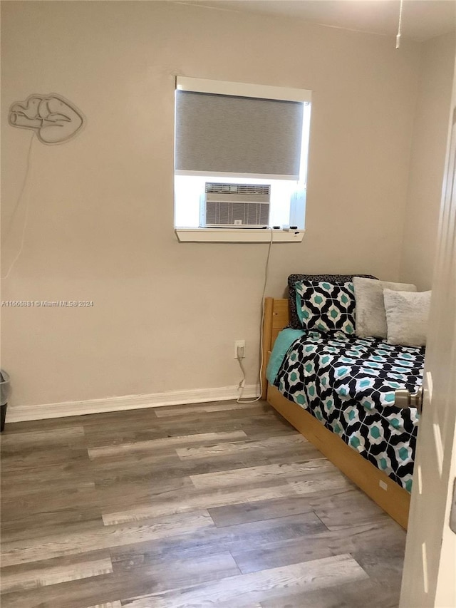 bedroom with cooling unit and hardwood / wood-style flooring