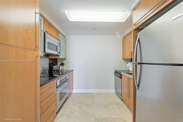 kitchen featuring brown cabinetry, baseboards, dark countertops, and stainless steel appliances