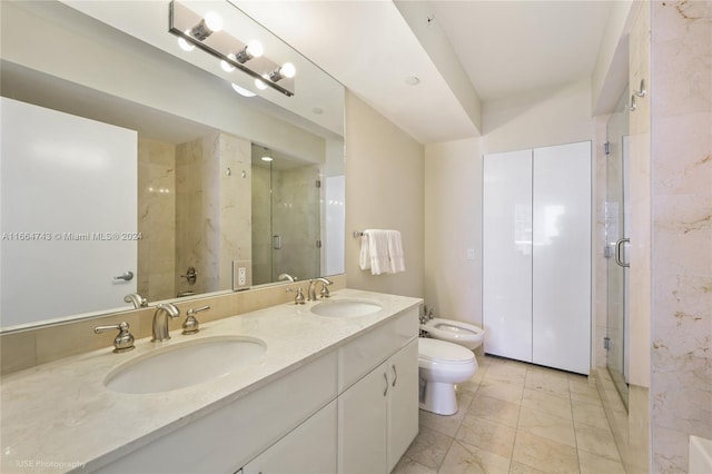 bathroom with a bidet, vanity, toilet, and a shower with door