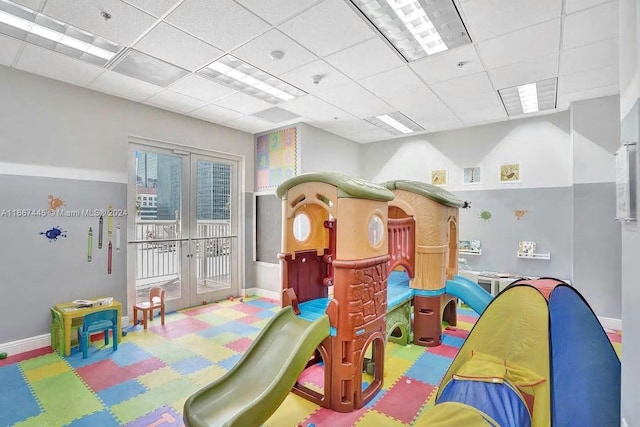 playroom featuring a drop ceiling and french doors