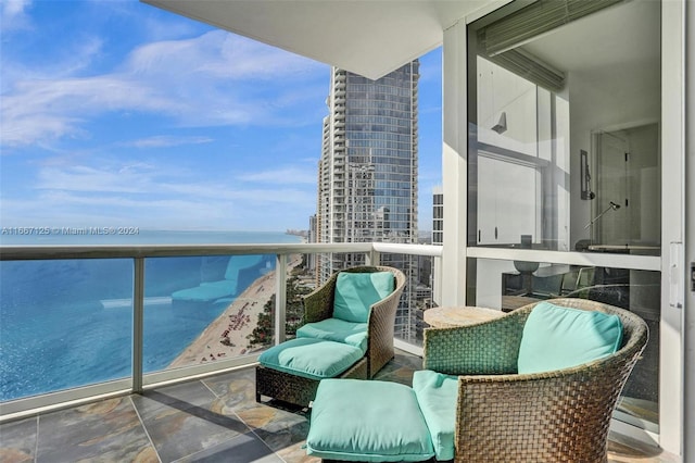 balcony featuring a water view and a beach view