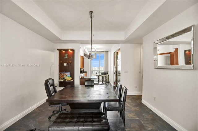 dining area with a notable chandelier and a tray ceiling