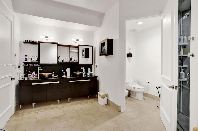 bathroom with vanity, toilet, and tasteful backsplash