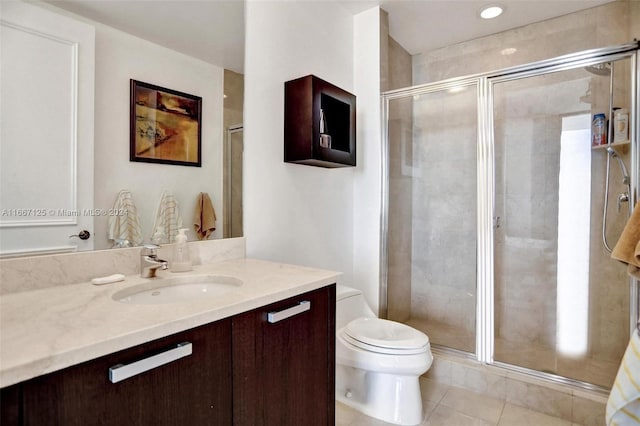 bathroom with vanity, a shower with shower door, toilet, and tile patterned floors