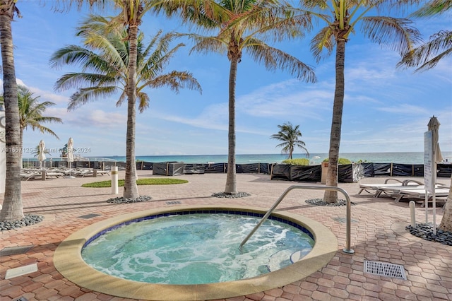 view of swimming pool featuring a community hot tub and a water view