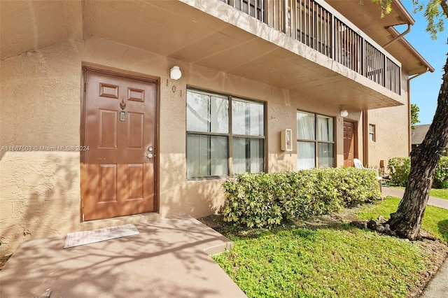 view of exterior entry with a balcony