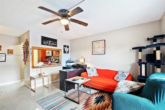 living room featuring ceiling fan, a textured ceiling, and light tile patterned floors