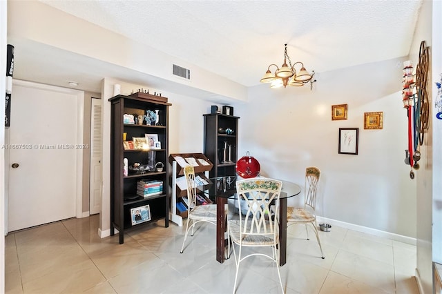 dining room featuring an inviting chandelier, a textured ceiling, and tile patterned flooring