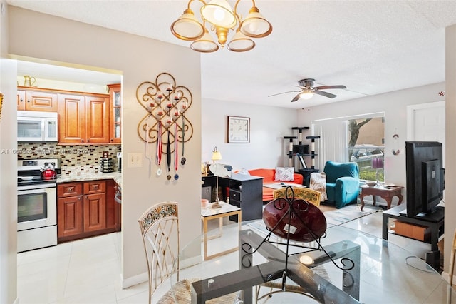 kitchen featuring a textured ceiling, ceiling fan with notable chandelier, tasteful backsplash, and white appliances