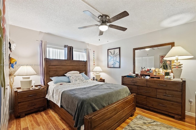 bedroom featuring a textured ceiling, light hardwood / wood-style floors, and ceiling fan