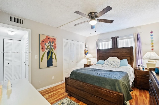 bedroom with ceiling fan, a textured ceiling, a closet, and light hardwood / wood-style floors