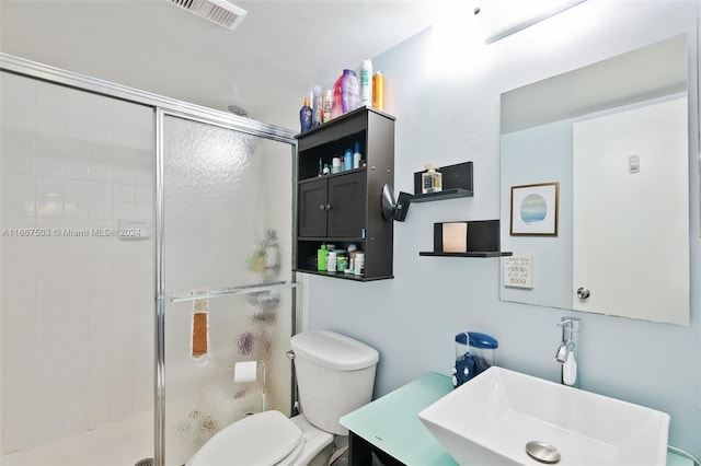 bathroom with vanity, a shower with shower door, and toilet