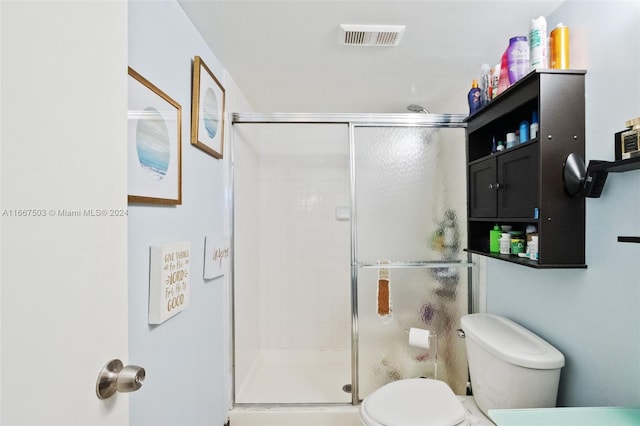 bathroom featuring walk in shower and toilet