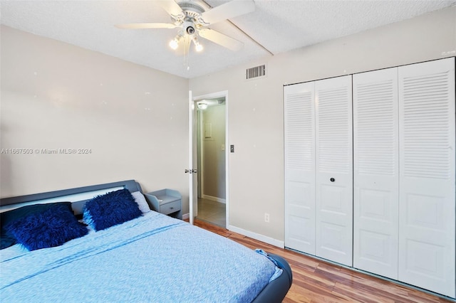 bedroom featuring a textured ceiling, ceiling fan, a closet, and hardwood / wood-style flooring