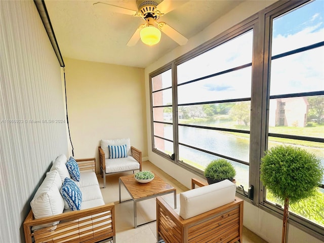 sunroom featuring a water view and ceiling fan