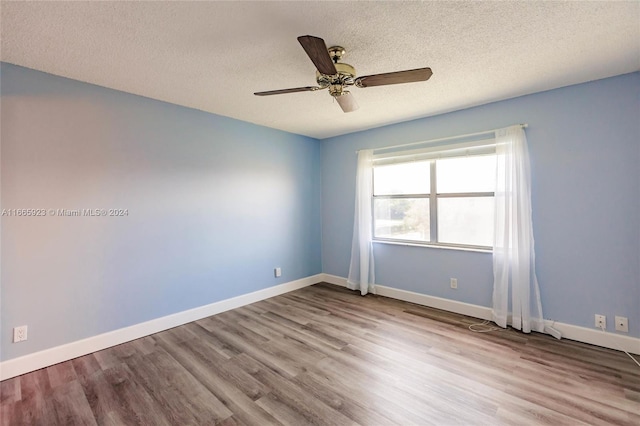 unfurnished room with ceiling fan, a textured ceiling, and light wood-type flooring