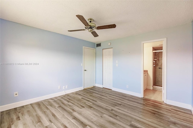 9460 Sunrise Lakes Blvd Unit 309, Sunrise, FL 33322 - unfurnished bedroom featuring wood finished floors, baseboards, a textured ceiling, and ensuite bath