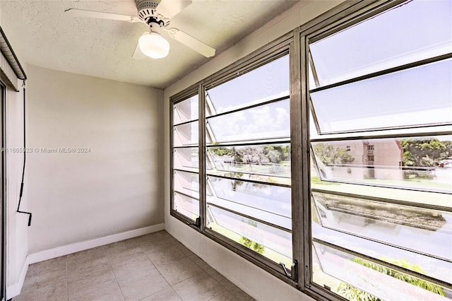 unfurnished sunroom featuring ceiling fan