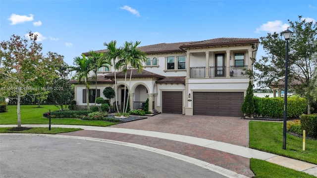 mediterranean / spanish home featuring a balcony, a front lawn, and a garage