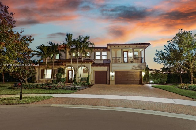 mediterranean / spanish-style house featuring a balcony, a garage, and french doors