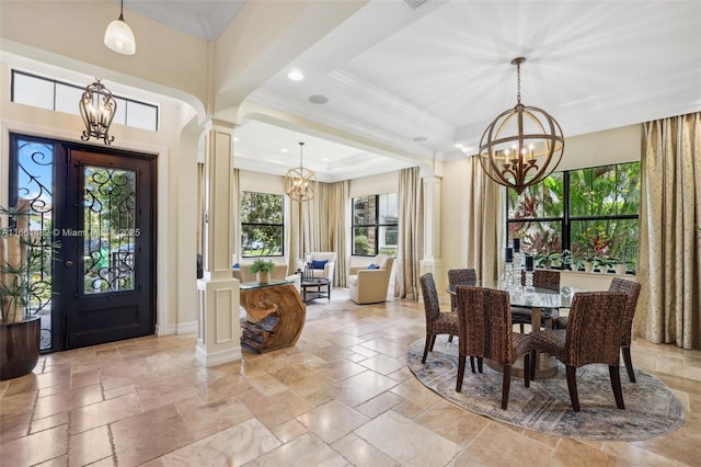 dining space featuring ornate columns, an inviting chandelier, crown molding, and a tray ceiling