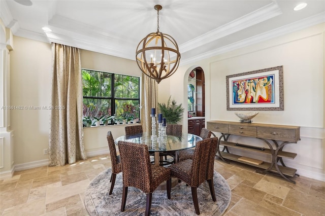 dining area featuring ornamental molding, a tray ceiling, and a notable chandelier