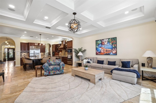 living room with coffered ceiling, beam ceiling, a notable chandelier, and ornamental molding