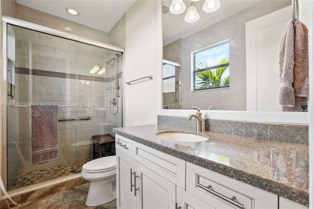 bathroom featuring toilet, an enclosed shower, and vanity