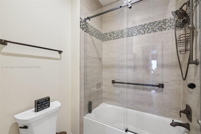 bathroom featuring toilet and combined bath / shower with glass door