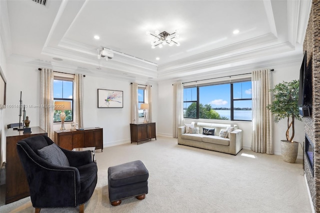 carpeted living room with crown molding and a tray ceiling