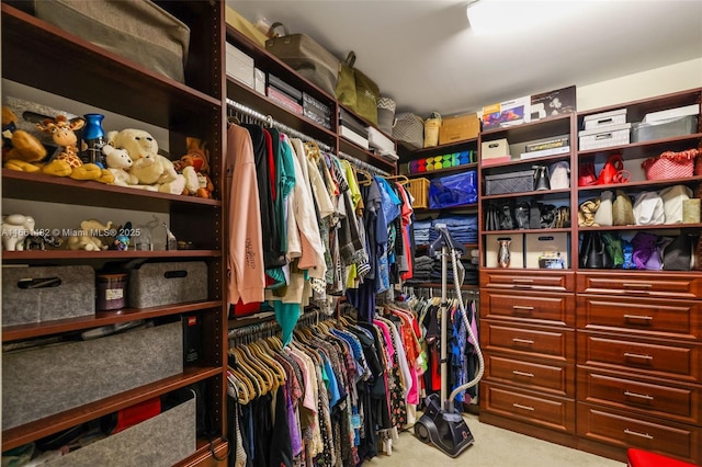 walk in closet featuring carpet flooring