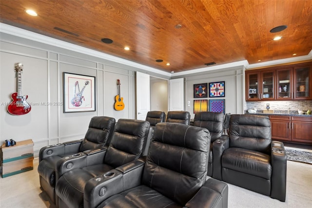 home theater room featuring light colored carpet, bar area, crown molding, and wood ceiling