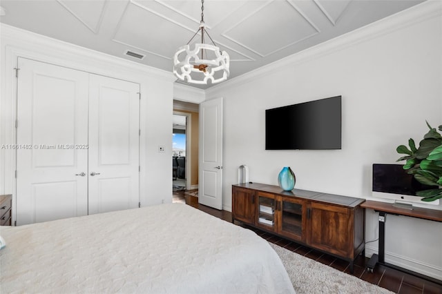 bedroom with crown molding, coffered ceiling, a chandelier, and a closet